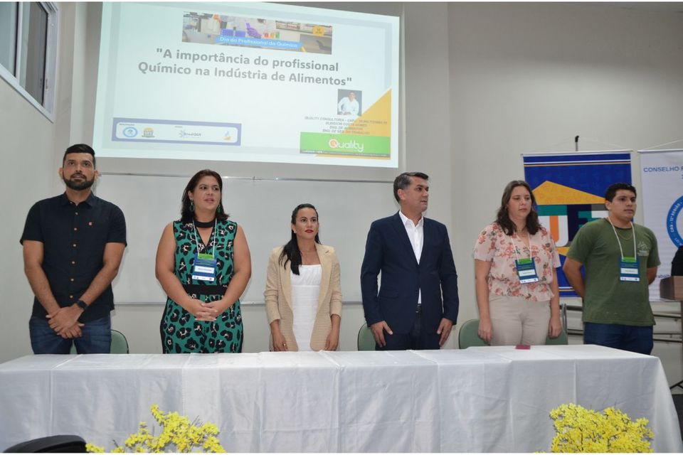 Grupo de pessoas em pé compondo a mesa do evento